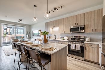 A modern kitchen with wooden cabinets and a large island.